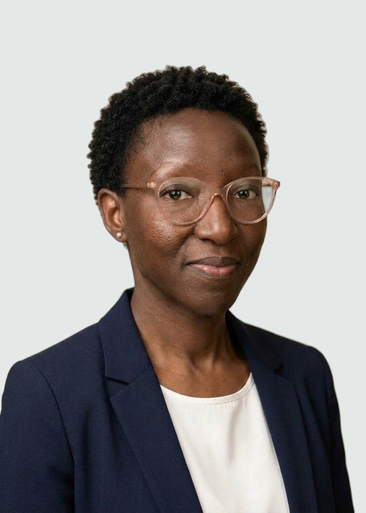 Sibongile, smiling, in a navy jacket and clear-framed glasses
